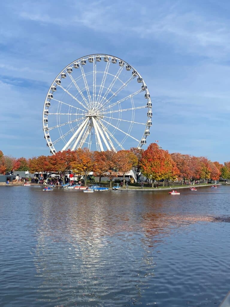 Grande roue à Montréal à l'arrière plan avec un lac et les couleurs des arbres orange rouge au second plan